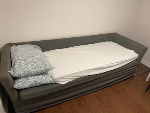 a bed with two pillows on top of it at Private Basement Room 0363 in Toronto