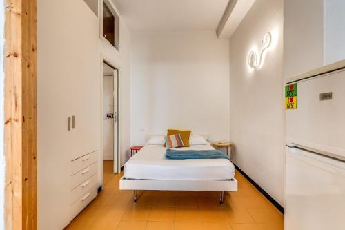 ラ・スペツィアにあるAwesHomeItaly - Cinque Terre Colors Studioの小さなベッドルーム(ベッド1台、冷蔵庫付)