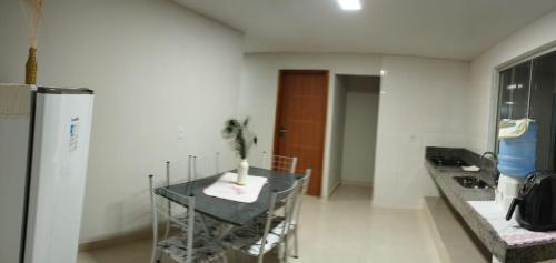 ein Esszimmer mit einem Tisch und einem Kühlschrank in der Unterkunft Residencial Casa Grande - Apto 03 in Santa Cruz Cabrália