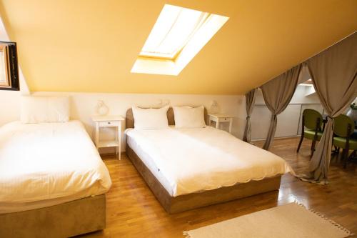 a bedroom with two beds and a skylight at All Elevens 11 Apartments in Bitola