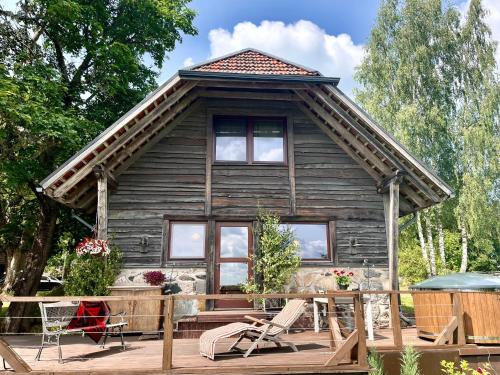 eine Blockhütte mit einem Tisch und Stühlen davor in der Unterkunft Mājiņa ar pirti ,lauku apvidū. 