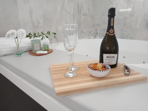 a bottle of wine and a glass on a wooden cutting board at Rosy's House in Scafati