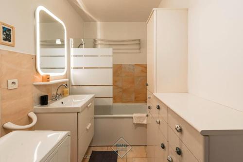 a white bathroom with a sink and a mirror at Palissy apartment near Disneyland in Bussy-Saint-Georges
