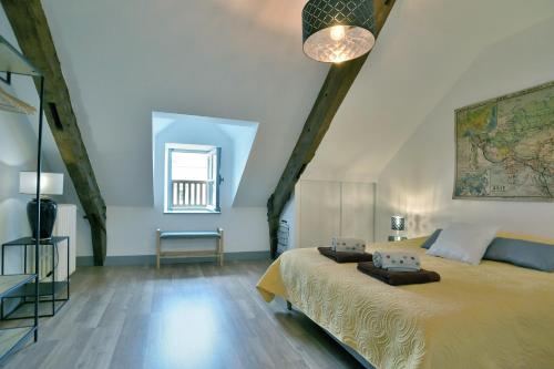 um quarto com uma cama grande e uma janela em Le Sainte Catherine - Appt centre-historique em Dinan