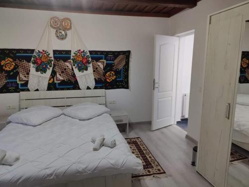 a bedroom with a large white bed with white sheets at Casa Godja Oncesti in Onceşti