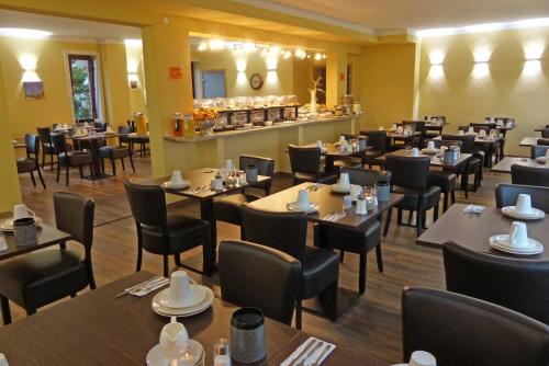 a restaurant with tables and chairs and a counter at Hotel Neptuns Ankerplatz in Cuxhaven
