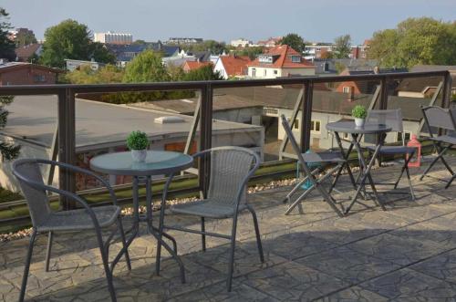 eine Terrasse mit 2 Tischen und Stühlen auf dem Balkon in der Unterkunft Hotel Neptuns Ankerplatz in Cuxhaven