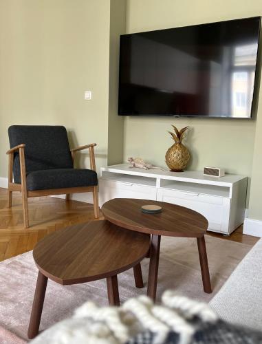 a living room with a tv and a chair and a table at Das Domizil in Klagenfurt
