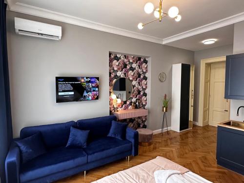 a living room with a blue couch and a mirror at Premium Apartment in Spiski Palace in Krakow