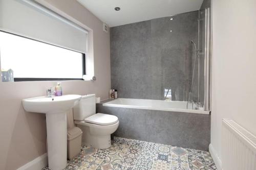 ein Badezimmer mit einem Waschbecken, einem WC und einer Badewanne in der Unterkunft House in the Gaeltacht Quarter in Belfast