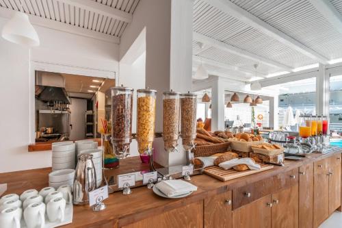 a bakery with bread and other items on a counter at Aloe Hotel - Adults Only in Faliraki