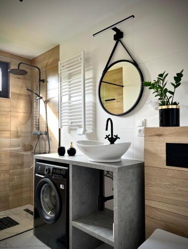 a bathroom with a sink and a washing machine at DUO Dom Kopalino in Kopalino