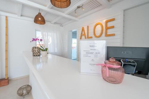 a kitchen with a white counter with an aloe sign at Aloe Hotel - Adults Only in Faliraki