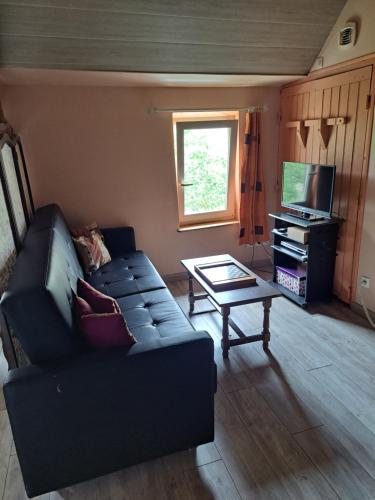 a living room with a couch and a coffee table at La Hulottière-Gîte La Grange in Cessières