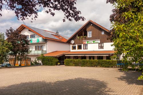 een groot wit gebouw met een bruin dak bij Tonis Tenne in Eschbach