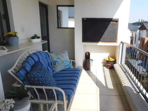 un sofá sentado en un balcón con TV en Ballito Beach Vibes at Ballito Hills, en Ballito