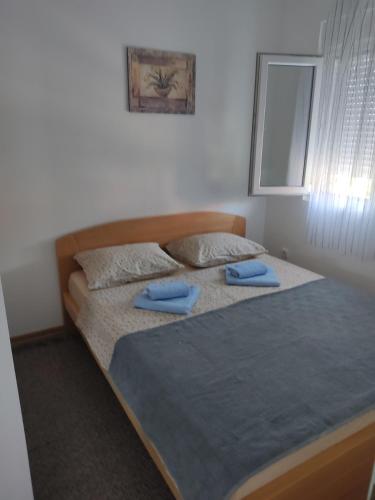 een slaapkamer met een groot bed met blauwe kussens bij Ivana apartman in Vrnjačka Banja