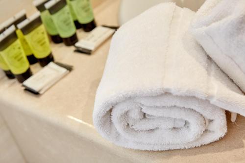 a roll of white towels sitting on a bathroom counter at Doña Lola in Castellón de la Plana