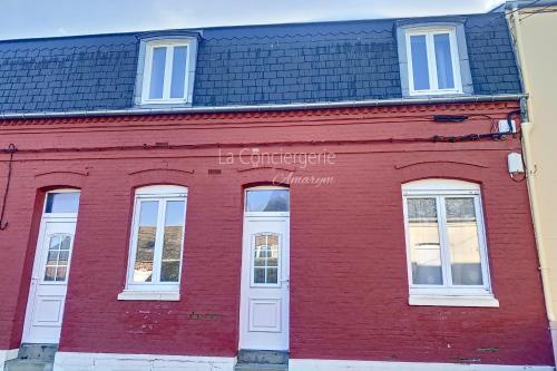 a red building with white windows and a black roof at AD41 - La Perle Marine Jolie maison avec jardin et terrasse in Ault