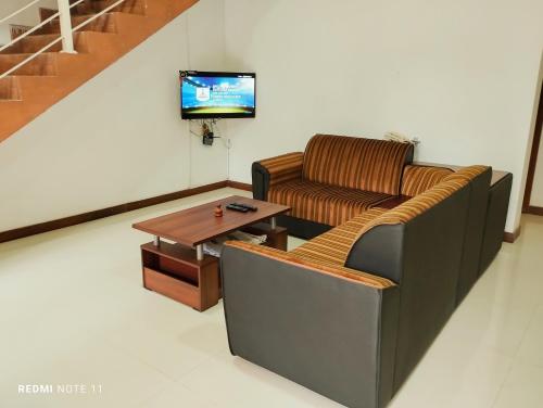 een woonkamer met een bank en een salontafel bij New White House in Colombo