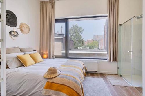 um quarto com uma cama grande e uma janela grande em Wonderful apartment in the center of Antwerp em Antuérpia