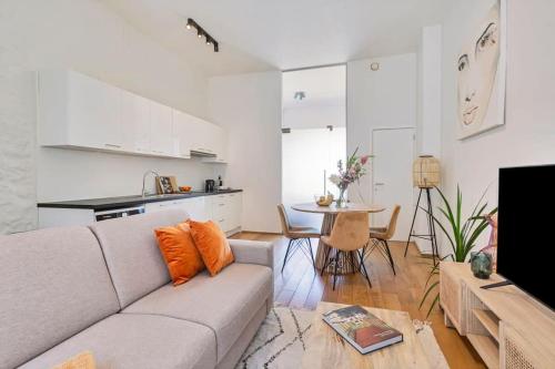 uma sala de estar com um sofá, uma mesa e uma cozinha em Wonderful apartment in the center of Antwerp em Antuérpia