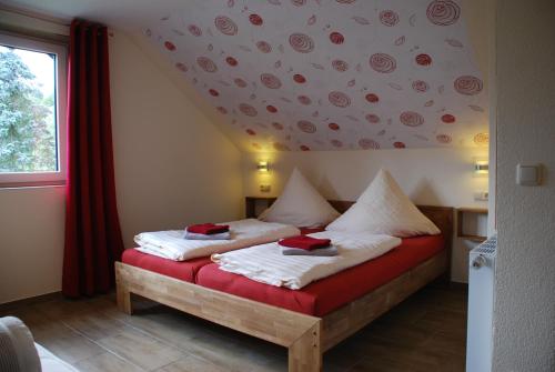een slaapkamer met een bed met rode en witte kussens bij Ferienoase Hinterhermsdorf in Hinterhermsdorf