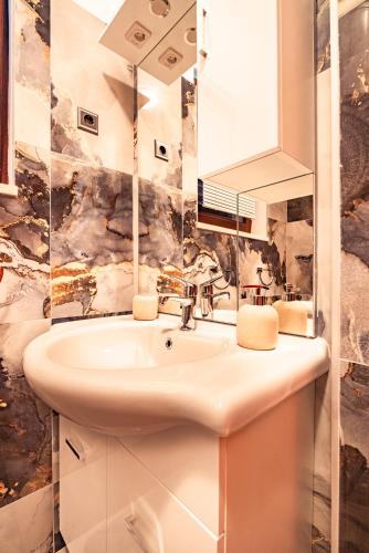 a bathroom with a sink and a mirror at Apartmani Baki 1 in Podstrana
