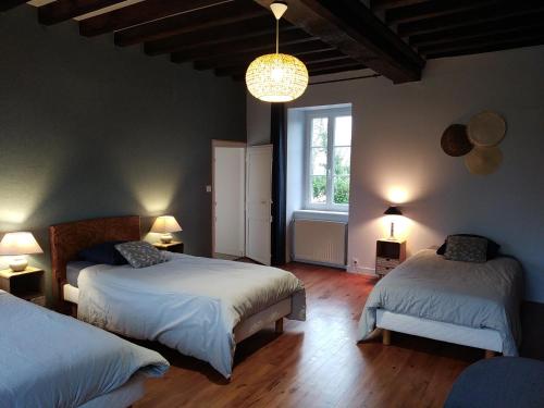 een slaapkamer met 2 bedden en een raam bij Le domaine des Ecureuils in Vassy
