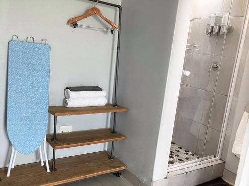 a bathroom with two wooden shelves and a shower at North Breeze Retreats in Durban