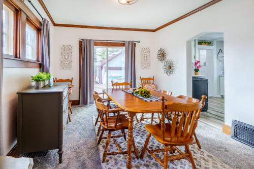 a kitchen and dining room with a wooden table and chairs at King Bed, Stocked Kitchen, Easy Driveway Parking, 2mi to Downtown & Coliseum in Fort Wayne
