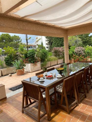 drewniany stół i krzesła na patio w obiekcie Panoramic sea view penthouse with jacuzzi and 450 sqm terrace w mieście Antibes