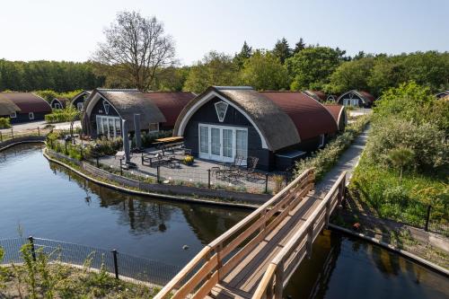 a house on a river with a wooden bridge at 't Landgoed Baars in Baars