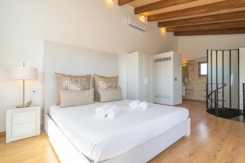 1 dormitorio con 1 cama blanca y 2 toallas en Son Morei de Ses Penyes, en Muro