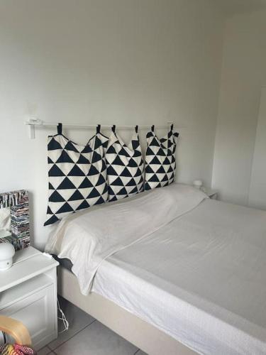 - un lit blanc avec des oreillers en noir et blanc dans l'établissement Casa vacanze da Tonino, à Noci