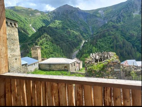 een balkon met uitzicht op een dorp in de bergen bij guest house "BETQIL" adishi in Adishi