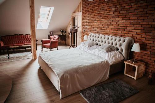 a bedroom with a large bed and a brick wall at Apartament z wanną wolnostojącą in Stare Miasto