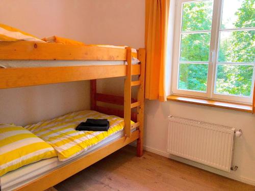 een slaapkamer met 2 stapelbedden en een raam bij The coach house in Altenherfen