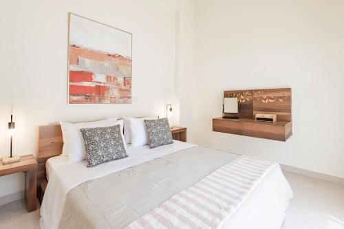 a white bedroom with a large bed and a desk at Halide Luxury Villa in Ixia