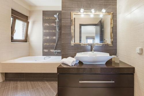 y baño con lavabo, bañera y espejo. en Halide Luxury Villa, en Ixia