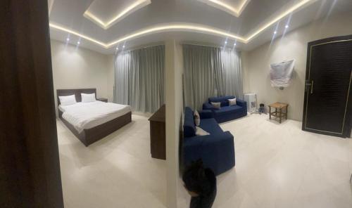1 dormitorio con 1 cama y 1 sofá azul en وحدات جنان en Ahad Rafidah