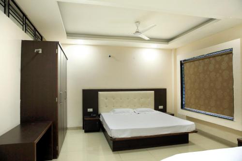 印多爾的住宿－Hotel Shri Raam Krishna Baag Indore，一间卧室设有一张大床和一个窗户。