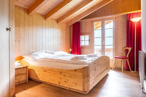 グリンデルワルトにあるApartment Schneerose - GRIWA RENT AGのベッドルーム1室(大型木製ベッド1台付)