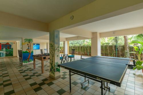 a living room with a ping pong table at Treehouse Blue Hotel & Serviced Apartments in Majorda