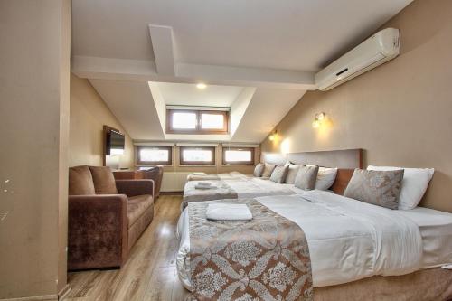 a bedroom with a large bed and a couch at Wide Suites Taksim in Istanbul