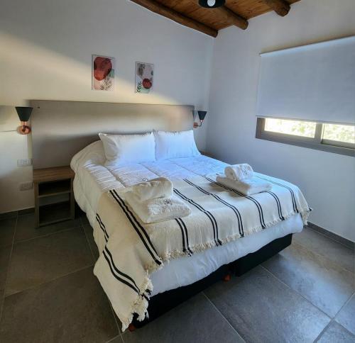 a bedroom with a bed with white sheets and a window at ARAUCARIA Resort in San Rafael