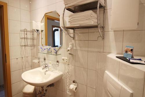 ein weißes Badezimmer mit einem Waschbecken und einem Spiegel in der Unterkunft Seerose in Bliesdorf