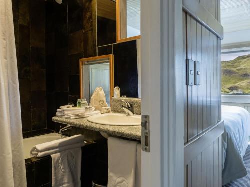 a bathroom with a sink and a mirror at Explora en Torres del Paine - All Inclusive in Torres del Paine
