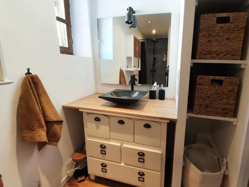 une salle de bain avec un lavabo et un miroir dans l'établissement Maison cosy en hyper-centre, à Agen