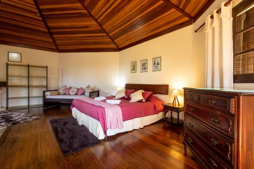 a bedroom with a large bed and a wooden ceiling at Pousada 3 Pinheiros in Campos do Jordão